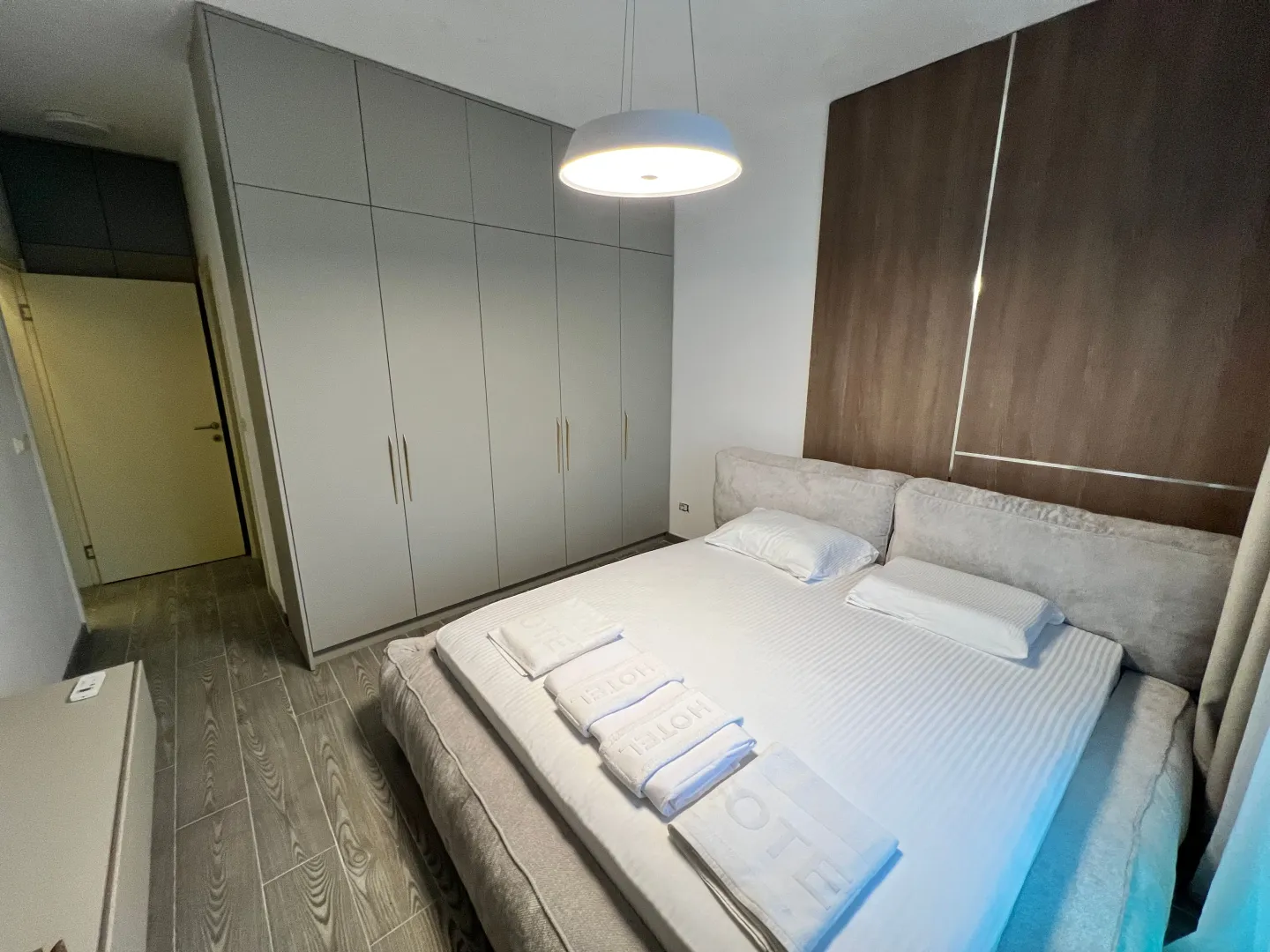 Modern furnished bedroom with a double bed and built-in wardrobe.