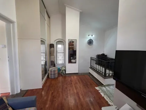 Spacious living room with wooden flooring, built-in wardrobe, and a staircase. - image 21