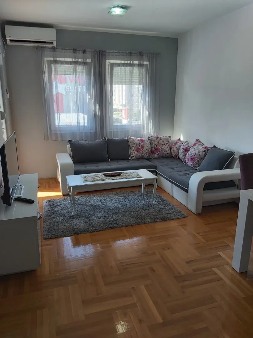 Svijetla dnevna soba sa ugaonom garniturom.