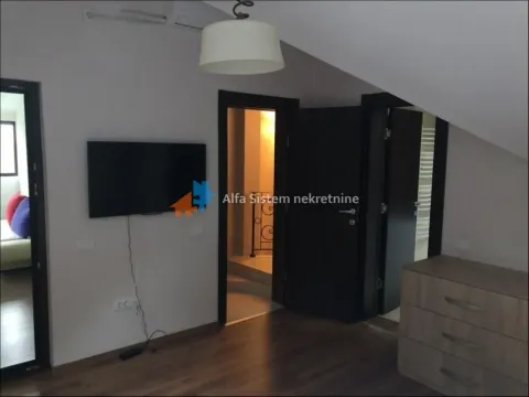 Bedroom with a TV, chest of drawers, and a sloped ceiling. - image 14