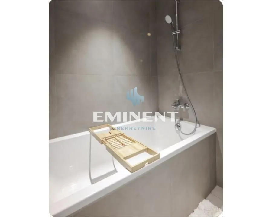 Modern bathroom with a bathtub and shower fixture.
