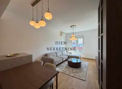 Living room with a sofa, dining table, and modern lighting. - image 6