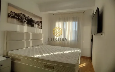 Bright bedroom with a double bed, window, and wall-mounted TV. - image 10