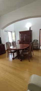 Dining room with a wooden table, chairs, and a cabinet. - image 11
