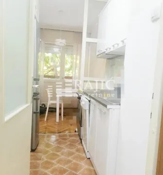 Small white kitchen with a dining area. - image 3