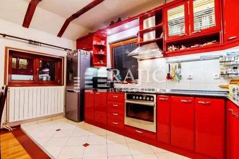 Spacious kitchen with red cabinetry and built-in appliances. - image 4