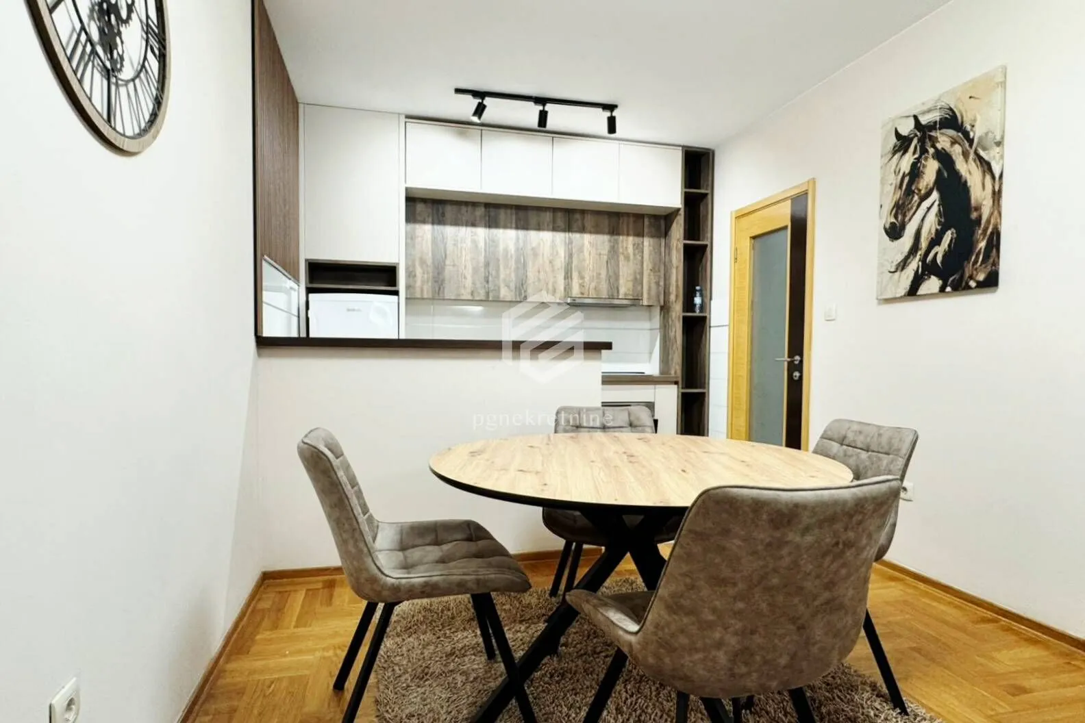 Dining area with a round table and chairs, connected to the kitchen.