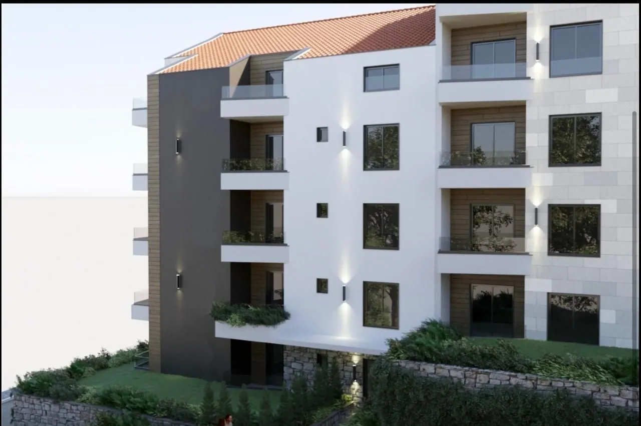 Spoljašnji izgled moderne stambene zgrade sa terasam i uređenim dvorištem.