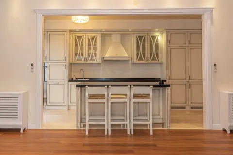 Classic kitchen with a bar counter and wooden cabinets. - image 4