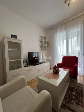 Dnevna soba sa garniturom, televizorom i izlazom na terasu. - image 2