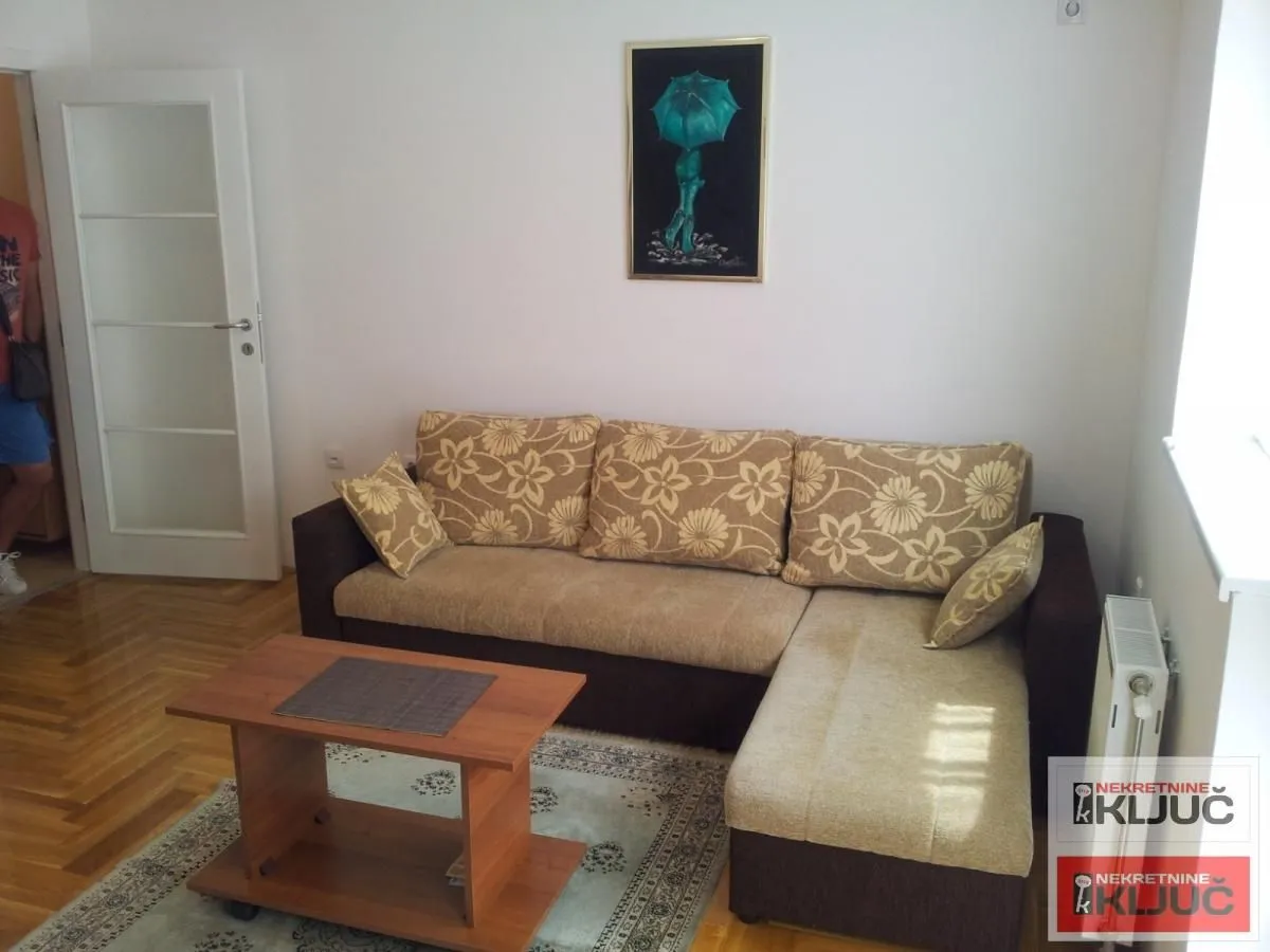 Dnevna soba sa ugaonom garniturom i stočićem.