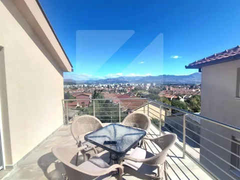 Namještena terasa sa stolom i stolicama i pogledom na grad. - image 13