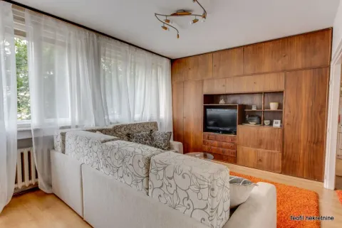 Living room with a sectional sofa and a large wooden wardrobe. - image 4