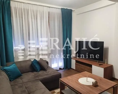 Furnished living room with a sofa and television.