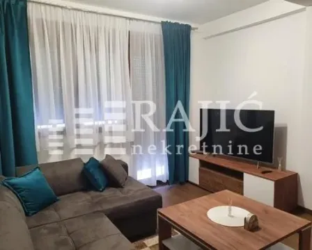 Furnished living room with a sofa and television. - image 2