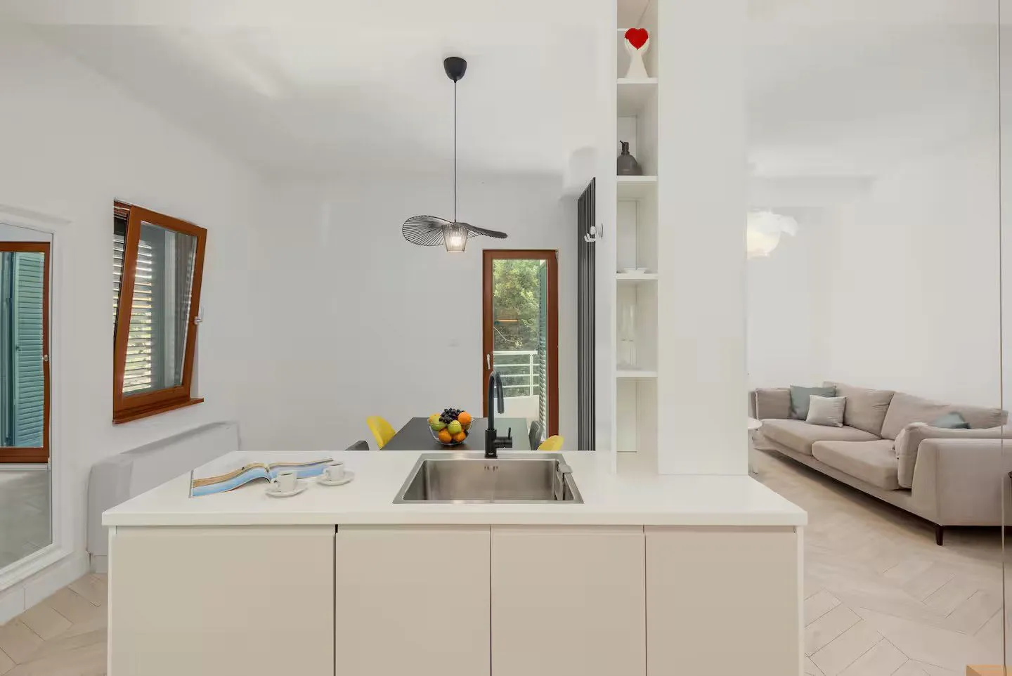 Modern kitchen with a sink on the island and a view of the living room.