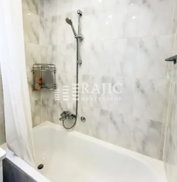 Bathroom with a bathtub and shower fixture. - image 11