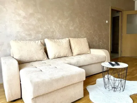 Living room with a beige sectional sofa and a small coffee table. - image 5