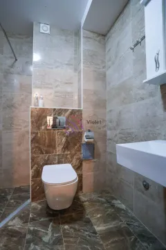 Manje kupatilo obloženo keramičkim pločicama sa WC šoljom i umivaonikom. - image 6