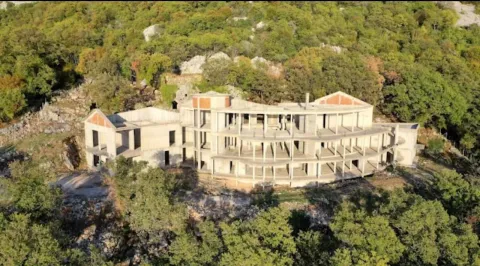 Pogled iz vazduha na nedovršeni objekat u izgradnji okružen zelenilom. - image 3