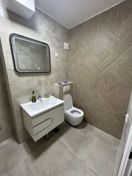 Modern bathroom with a wall-mounted sink and a backlit mirror. - image 13