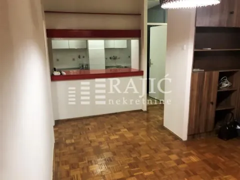 Living room with parquet flooring and a view of the kitchen counter. - image 3