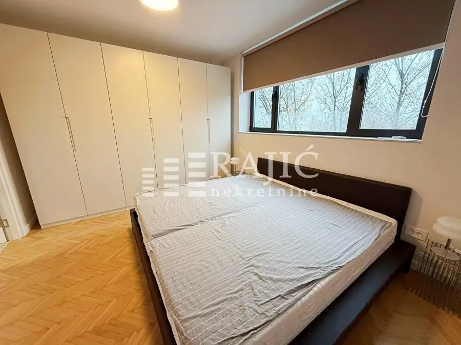 Bedroom with a double bed, large wardrobe, and a window.