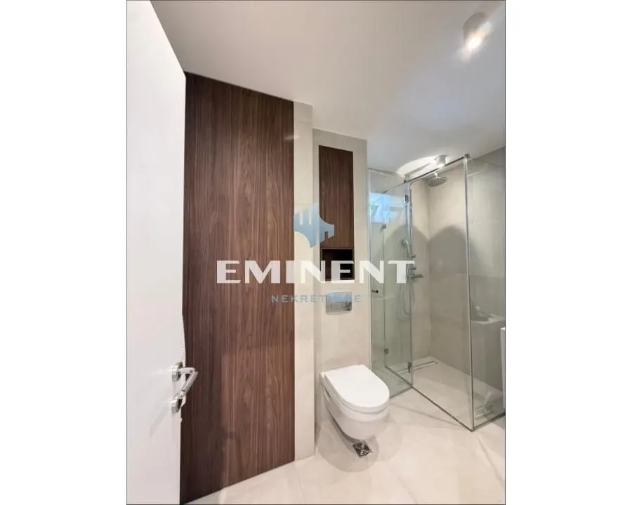 Modern bathroom with a walk-in shower and built-in toilet.