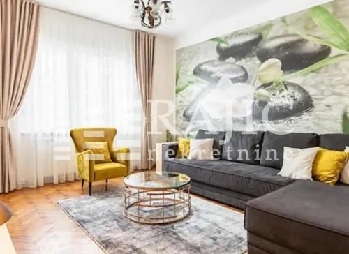 Comfortable living room with a sectional sofa, armchair, and a large window.