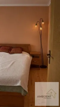 Spavaća soba sa bračnim krevetom, drvenim noćnim stočićem i lampom. - image 15