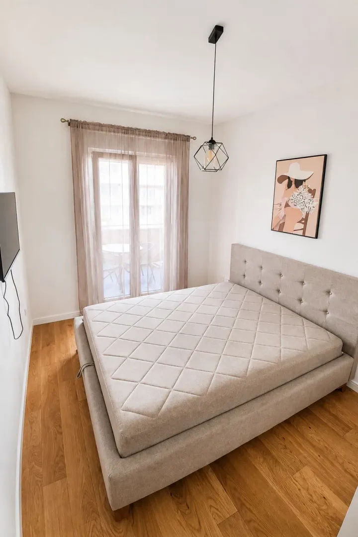 Bright and tidy bedroom with a double bed and access to the terrace.