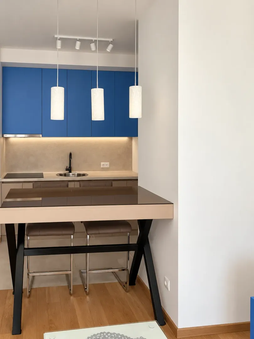 Modern kitchen with blue cabinetry and a bar table.