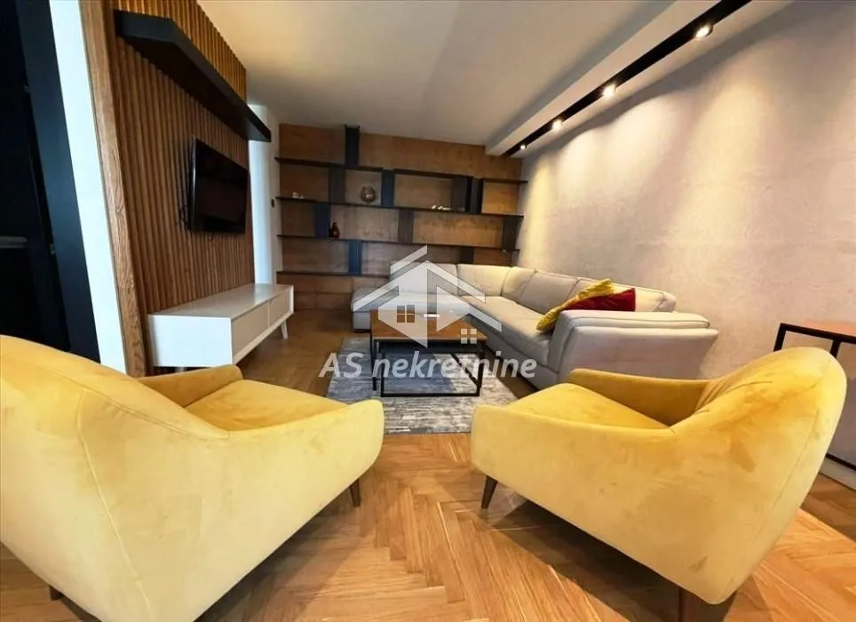 Living room with sofa, armchairs and built-in shelves.