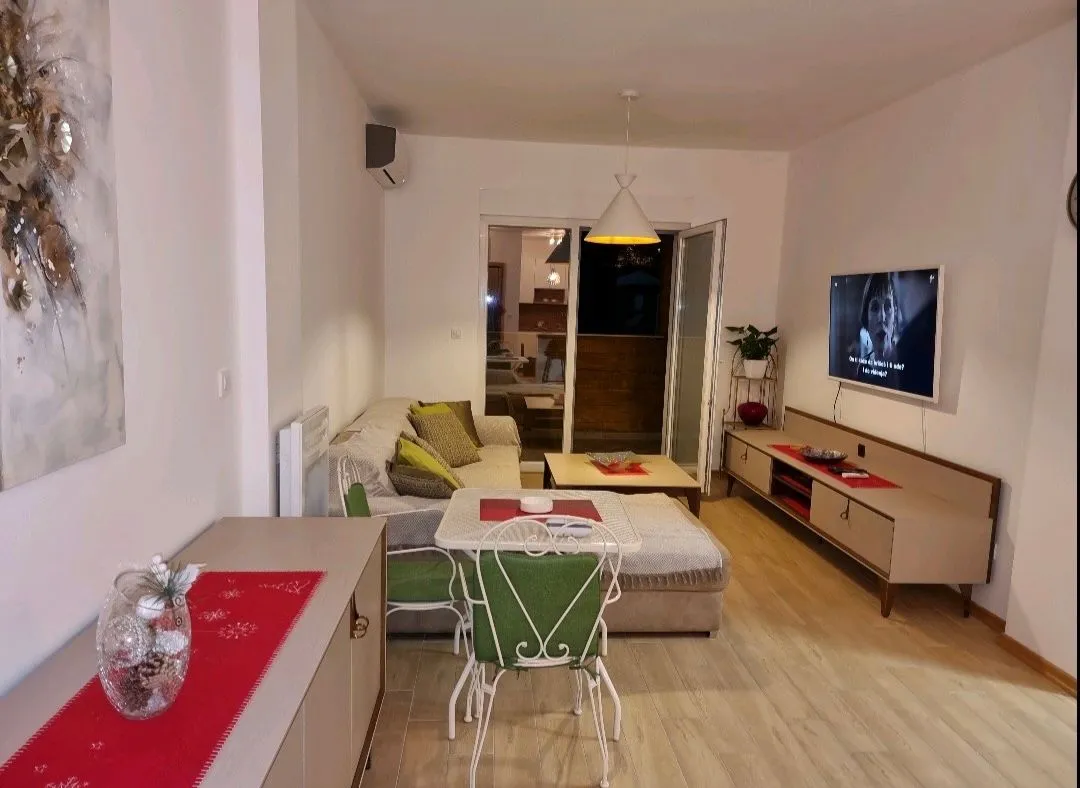 Living room with a sofa, TV, and dining table.