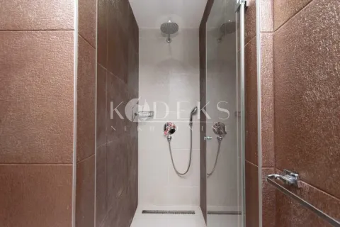 Tuš kabina u modernom kupatilu sa braon pločicama. - image 9