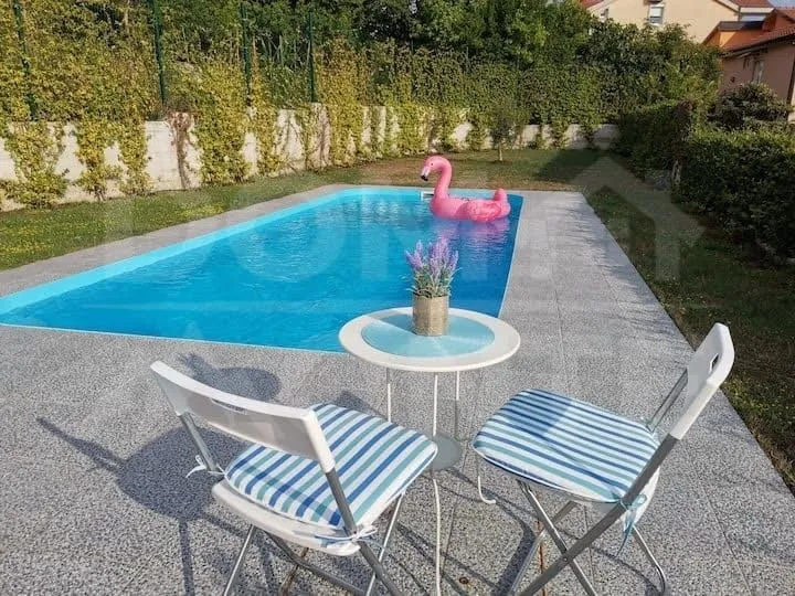 Yard with a swimming pool and seating set.