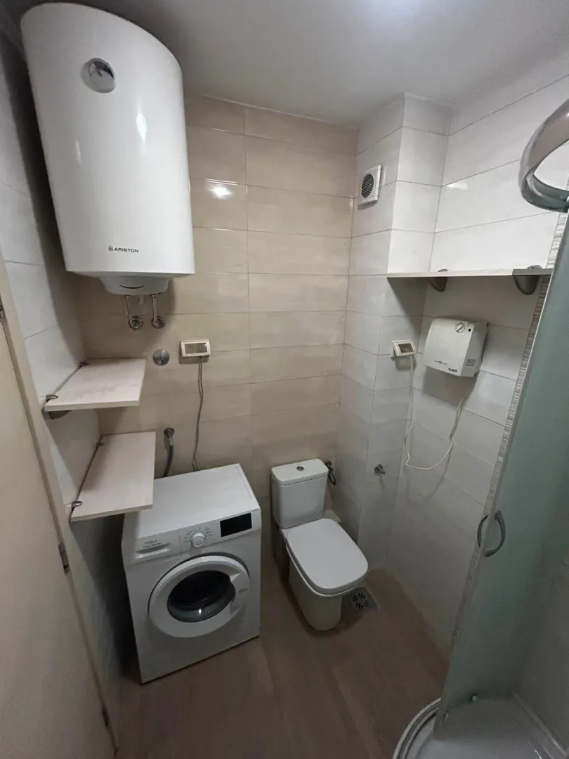 Kupatilo sa wc šoljom, tuš kabinom, mašinom za veš i bojlerom.