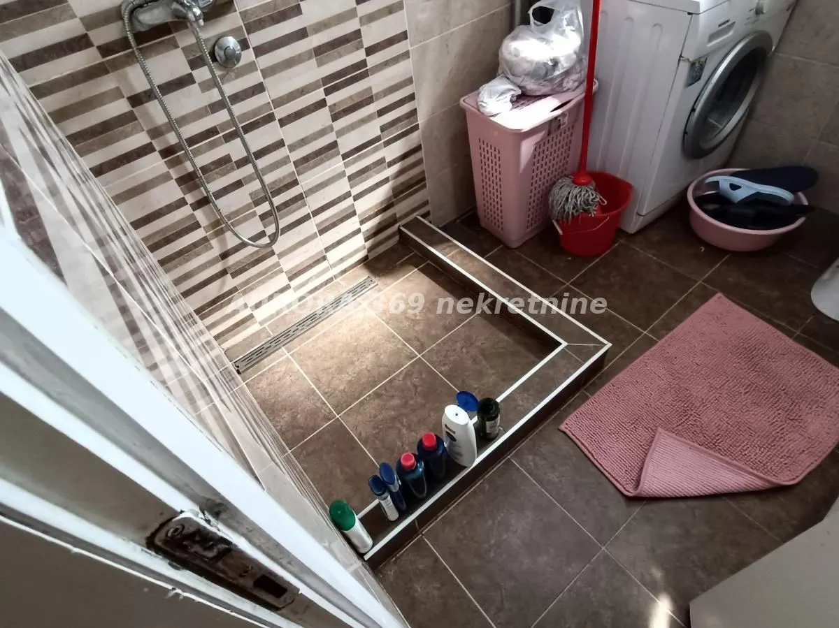 Kupatilo sa tuš kabinom i mašinom za veš.