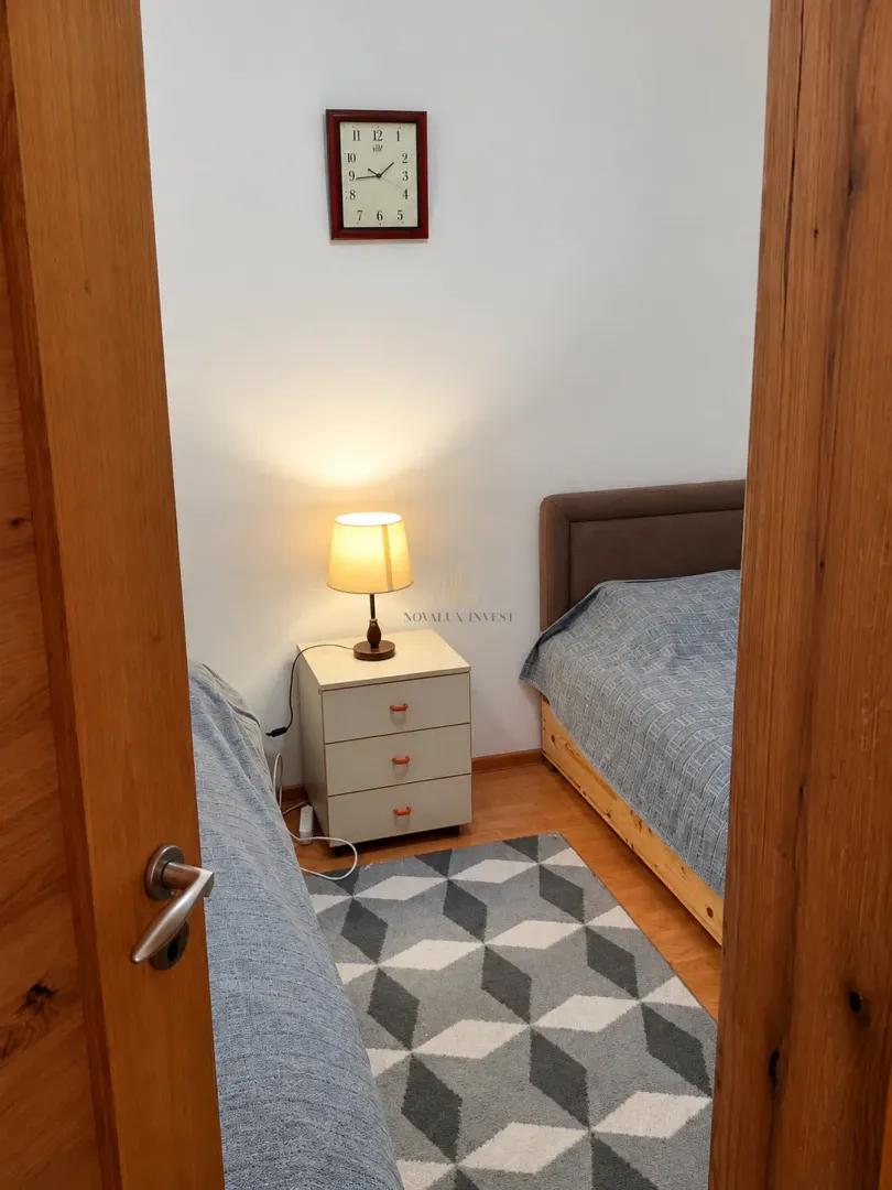 View from the doorway into a bedroom with two beds and a nightstand.