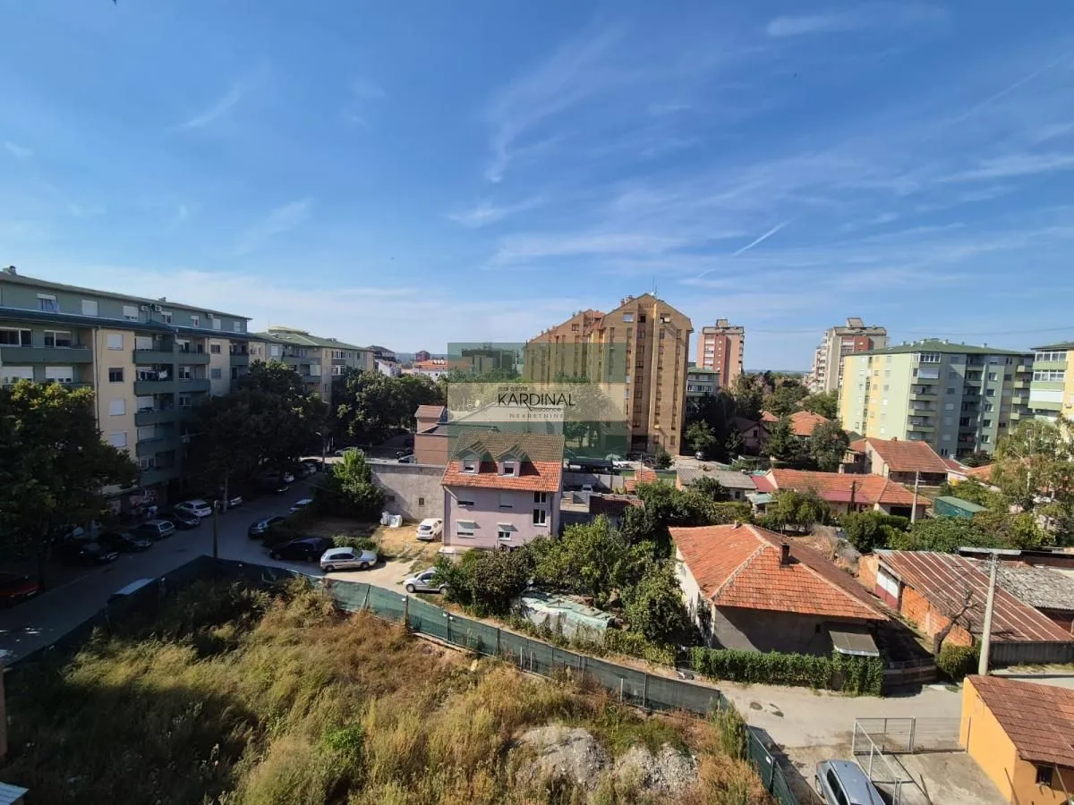 Pogled sa prozora na okolne zgrade i naselje.