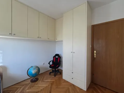 Small room with built-in wardrobes, an office chair, a globe, and parquet flooring. - image 9