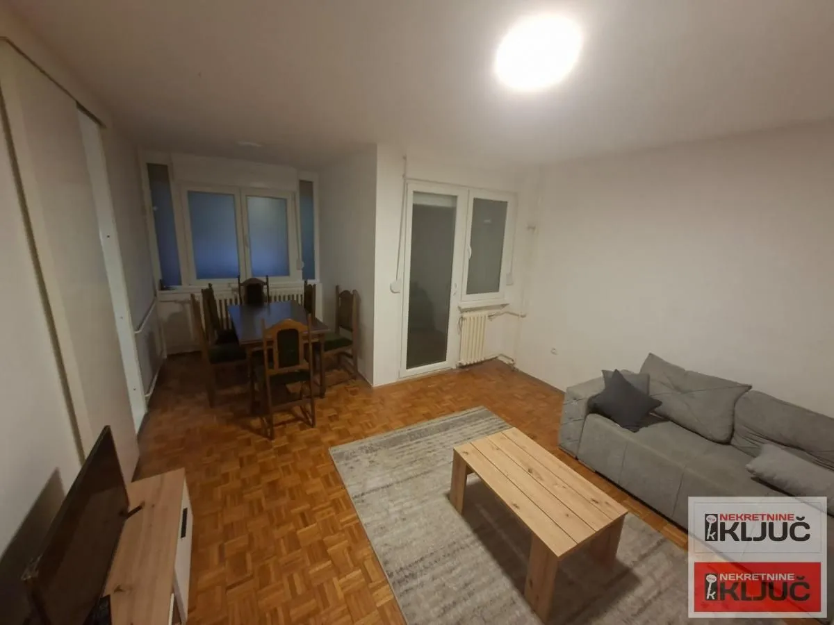 Dnevna soba sa trpezarijom i parketom na podu.