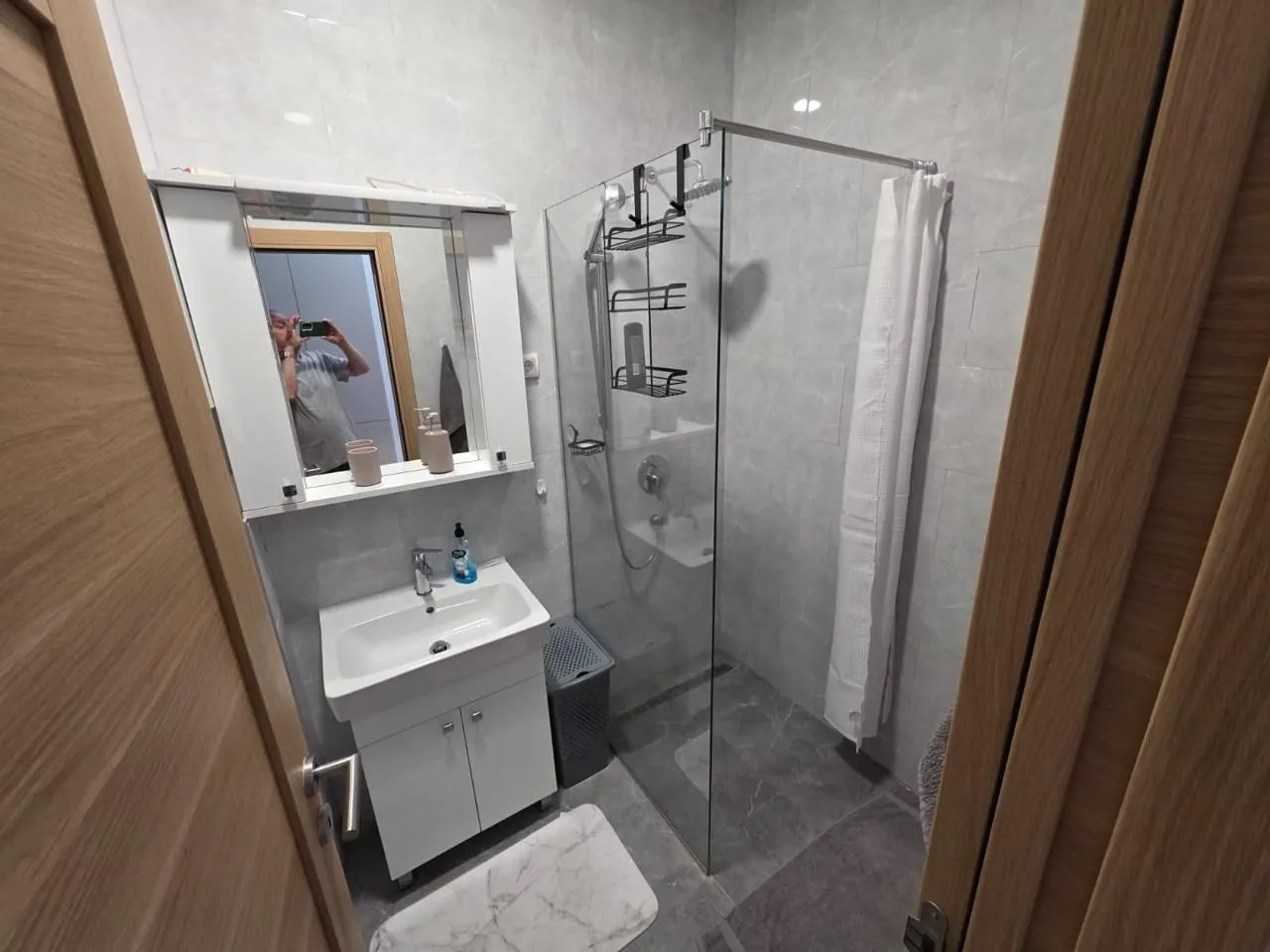 Moderne opremljeno kupatilo sa tuš kabinom i umivaonikom.