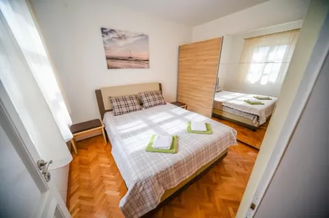 Uređena spavaća soba sa bračnim krevetom i drvenim podom. - image 6