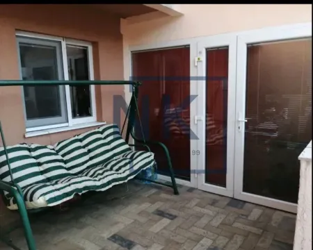 Covered terrace with a swing bench and tiled floor. - image 11