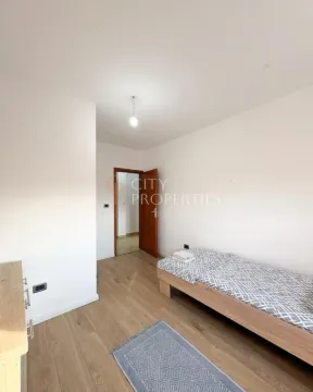 Manja spavaća soba sa krevetom i drvenim podom. - image 11