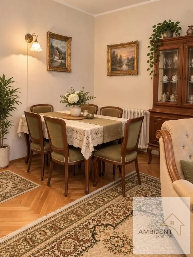 Trpezarija sa drvenim stolom, stolicama i vitrinom u klasičnom stilu.