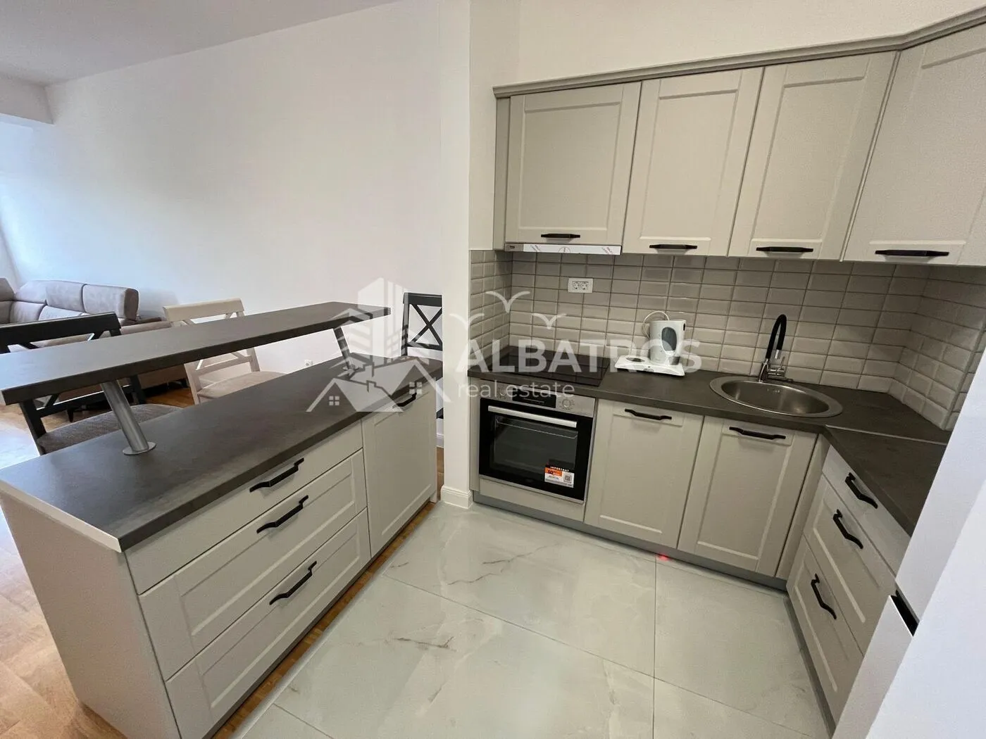 Small kitchen with beige cabinets and a breakfast bar.