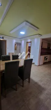 Trpezarija sa stolom i stolicama i pogledom na kuhinju. - image 2