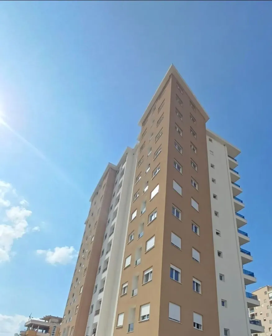 Exterior view of a modern multi-story residential building with balconies.